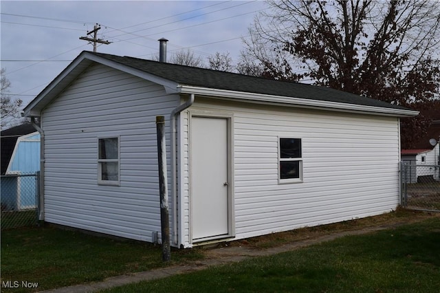 view of side of home featuring an outbuilding and a lawn