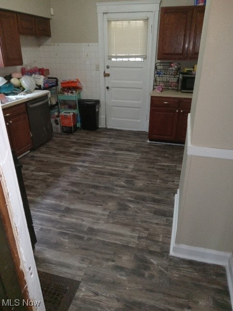 kitchen featuring dark hardwood / wood-style flooring and black dishwasher