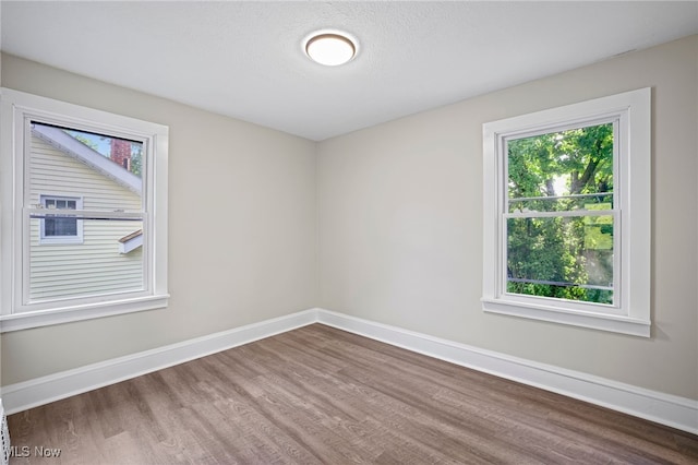 spare room featuring wood-type flooring and a textured ceiling