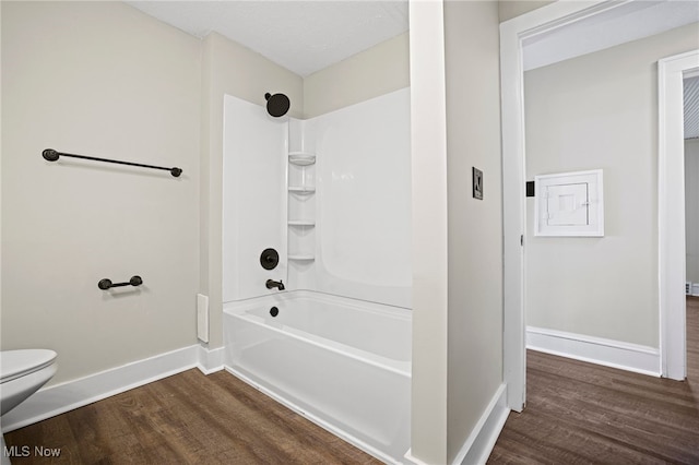 bathroom featuring hardwood / wood-style floors,  shower combination, and toilet