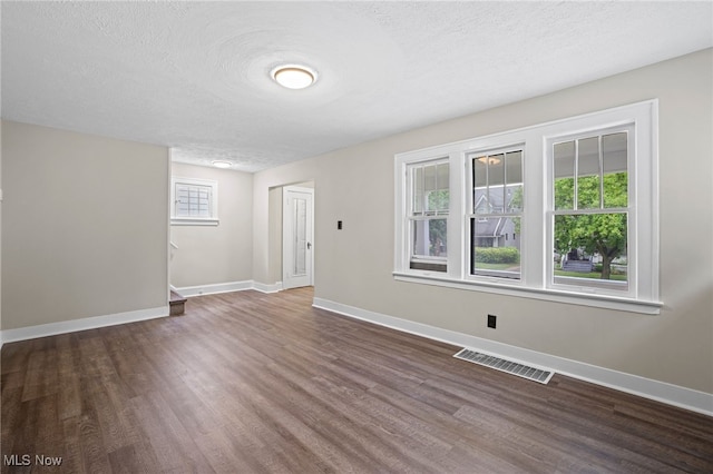 spare room with dark hardwood / wood-style flooring and a textured ceiling