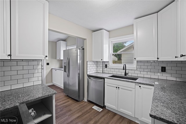 kitchen featuring dark hardwood / wood-style flooring, tasteful backsplash, stainless steel appliances, sink, and white cabinets