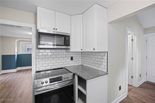 kitchen with white cabinets, stainless steel appliances, and dark hardwood / wood-style floors