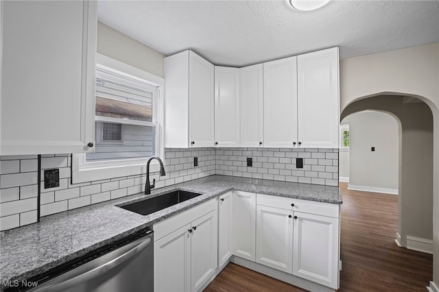 kitchen with dishwasher, stone counters, sink, dark hardwood / wood-style flooring, and white cabinetry