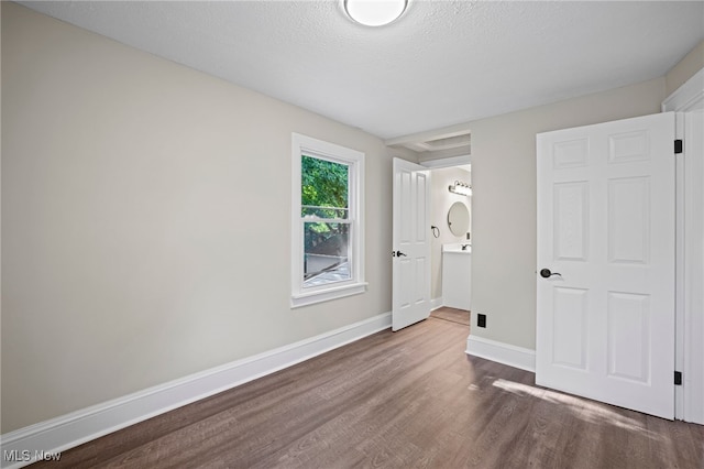 unfurnished bedroom featuring a textured ceiling and dark wood-type flooring