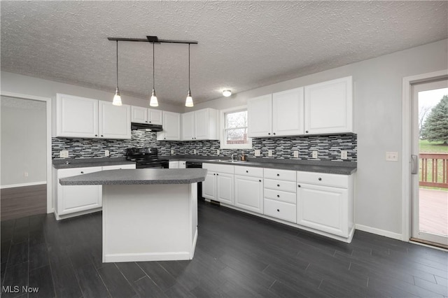 kitchen featuring electric range, decorative light fixtures, white cabinetry, and a wealth of natural light