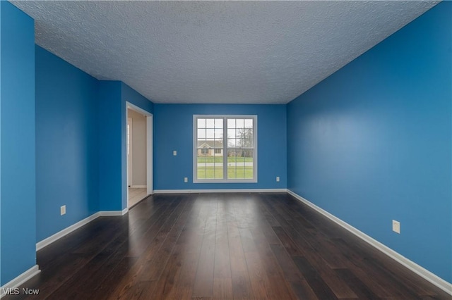 empty room featuring a textured ceiling and dark hardwood / wood-style flooring