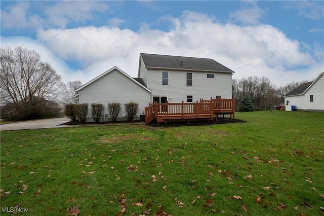 rear view of house with a lawn and a wooden deck