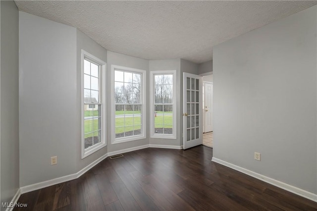 empty room featuring dark hardwood / wood-style floors and a textured ceiling