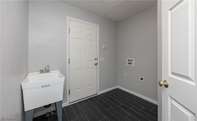 laundry area with hookup for an electric dryer, washer hookup, a textured ceiling, and sink