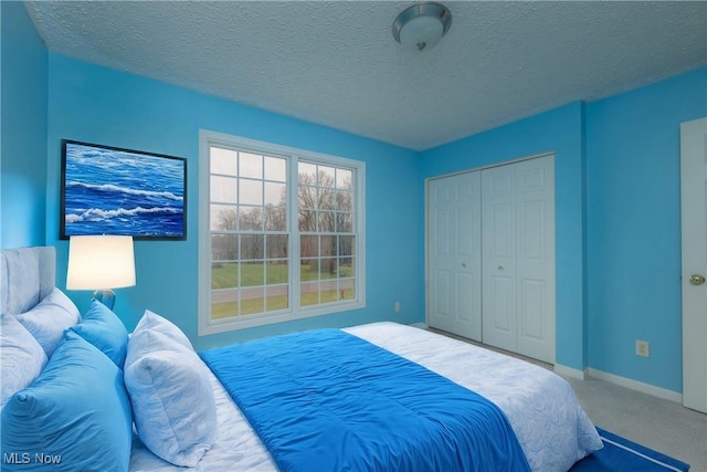 bedroom with carpet flooring, a textured ceiling, and a closet