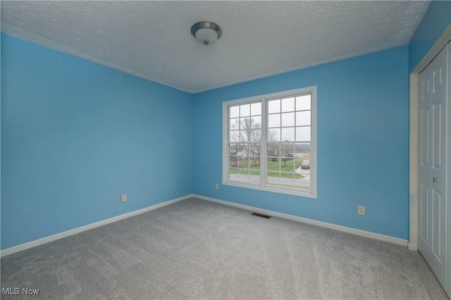 empty room featuring carpet flooring and a textured ceiling