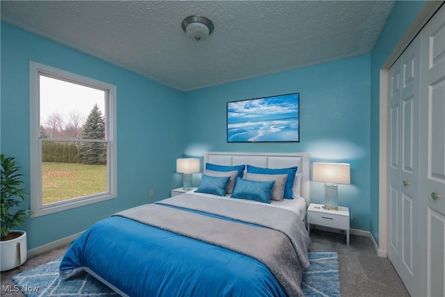 carpeted bedroom featuring a closet and a textured ceiling