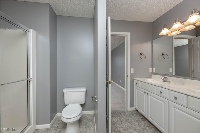 bathroom featuring tile patterned floors, vanity, toilet, and a textured ceiling