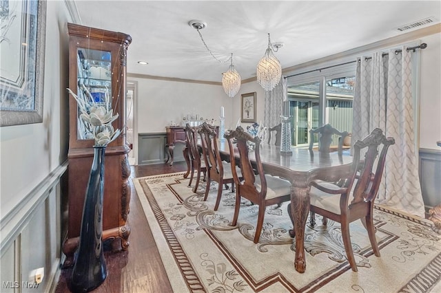 dining space featuring crown molding and dark wood-type flooring