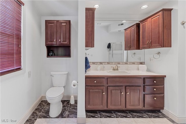 bathroom featuring vanity, a shower with shower door, and toilet