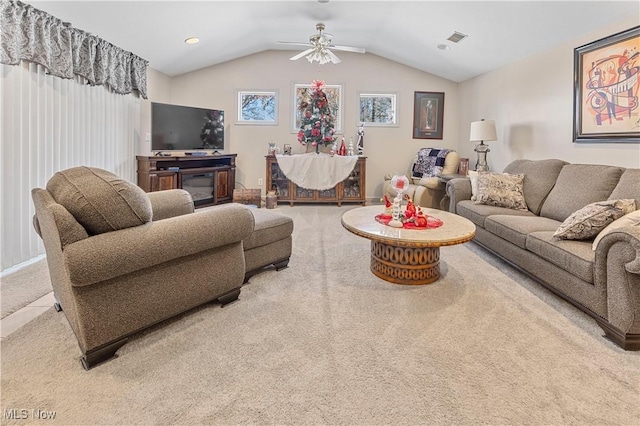 living room with ceiling fan, carpet floors, and vaulted ceiling