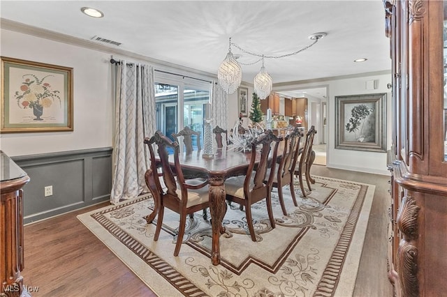 dining room with crown molding, dark hardwood / wood-style flooring, and a chandelier