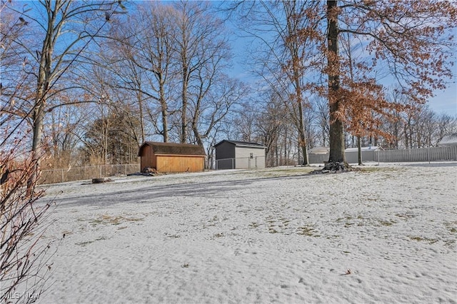 yard covered in snow with a storage shed