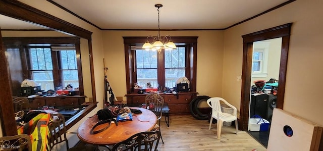 dining room with a notable chandelier, ornamental molding, and light hardwood / wood-style flooring