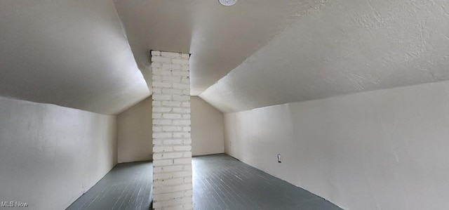 additional living space featuring dark hardwood / wood-style flooring and lofted ceiling