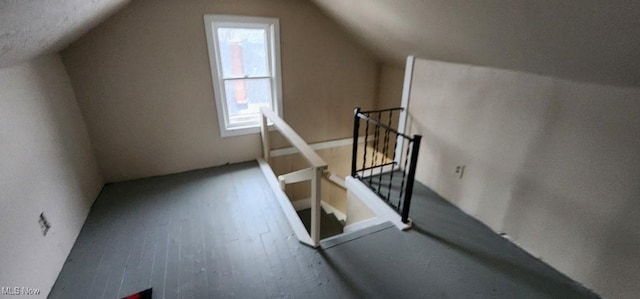 additional living space with hardwood / wood-style floors and lofted ceiling