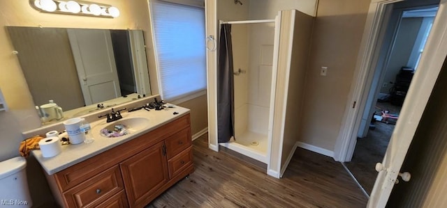 bathroom featuring hardwood / wood-style floors, vanity, toilet, and walk in shower