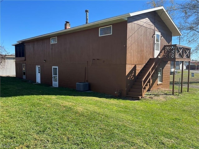 back of house featuring a lawn and a deck