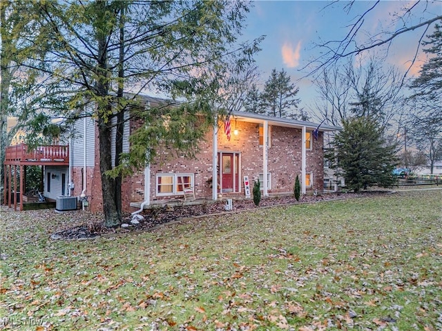 bi-level home featuring a wooden deck and a lawn