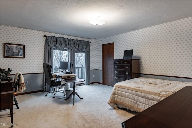 bedroom with light carpet and a textured ceiling