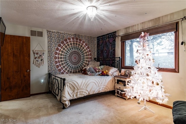 carpeted bedroom featuring a chandelier and a textured ceiling