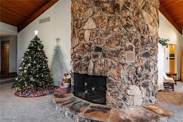 carpeted living room featuring a stone fireplace, high vaulted ceiling, and wooden ceiling