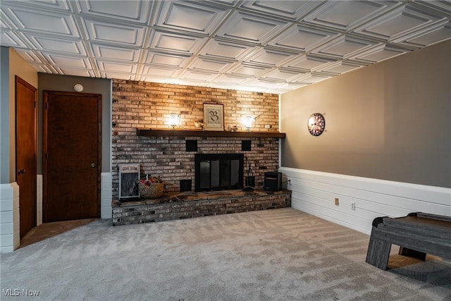 unfurnished living room with carpet flooring and a brick fireplace