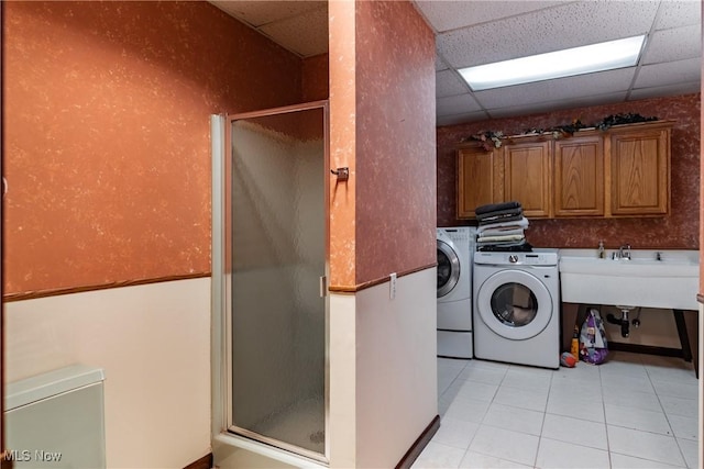 clothes washing area featuring cabinets, independent washer and dryer, and light tile patterned floors