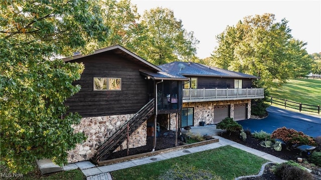 view of front of property featuring a front yard, a balcony, and a garage