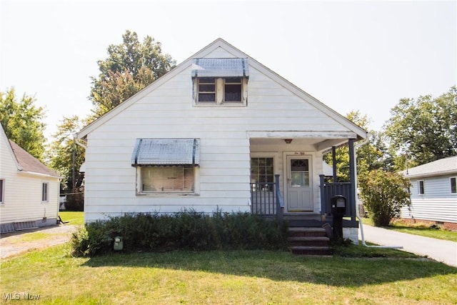 bungalow-style house featuring a front yard and covered porch