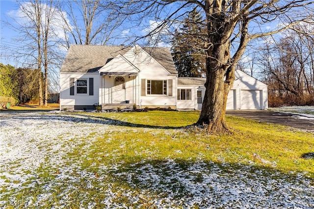 bungalow with a front yard, an outbuilding, and a garage