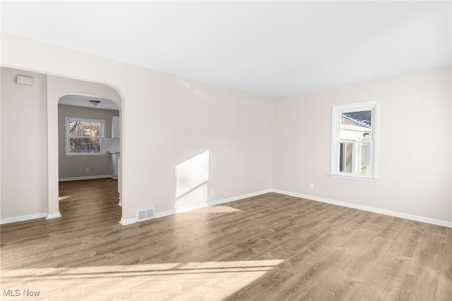 unfurnished room featuring a wealth of natural light and hardwood / wood-style floors