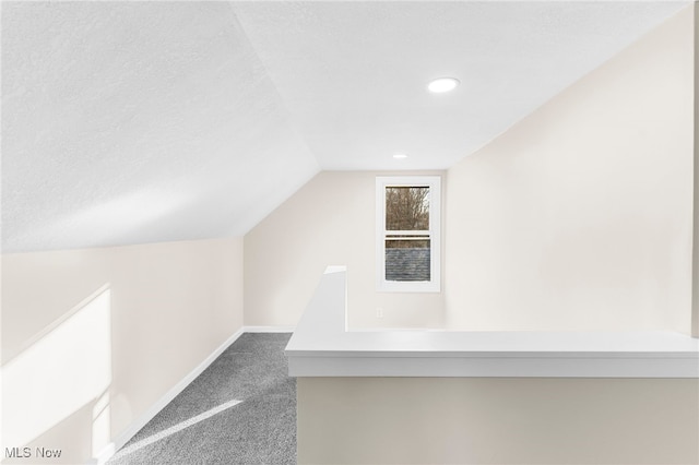 bonus room with carpet flooring, a textured ceiling, and vaulted ceiling