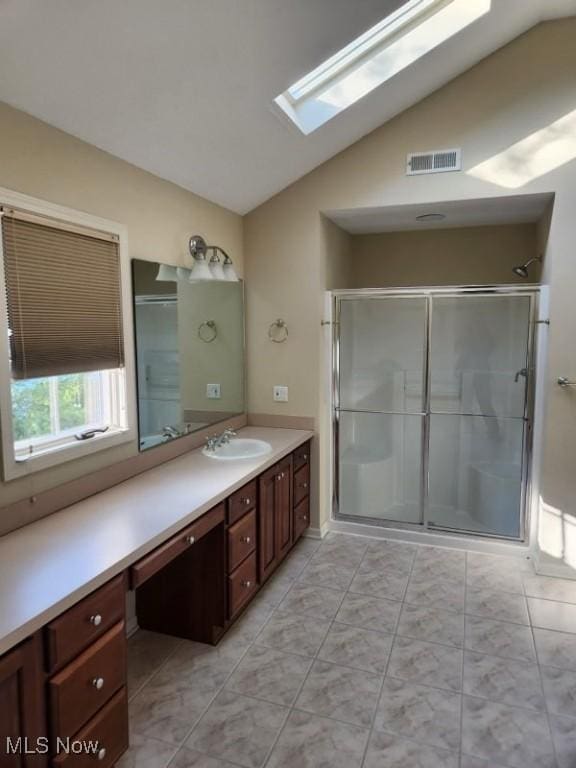 bathroom with vanity, an enclosed shower, and vaulted ceiling with skylight