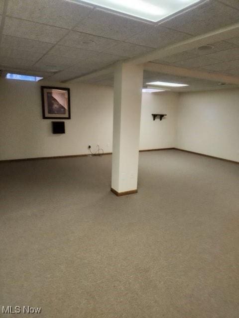 basement featuring carpet and a drop ceiling