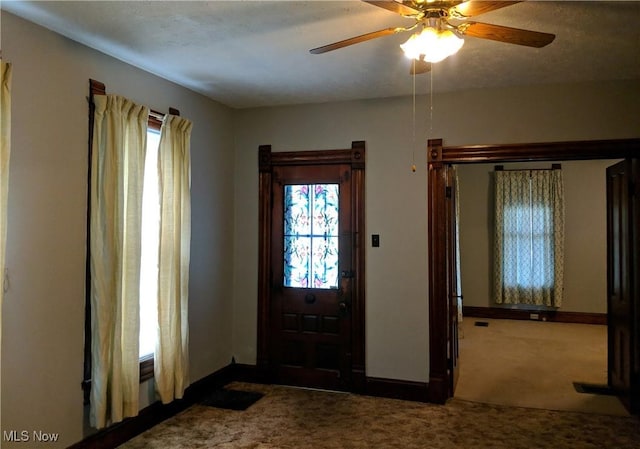 carpeted foyer with ceiling fan and a textured ceiling