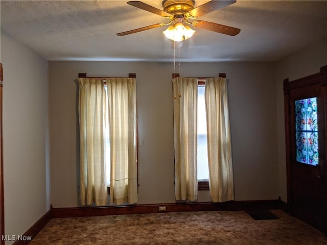 unfurnished room with ceiling fan and a textured ceiling