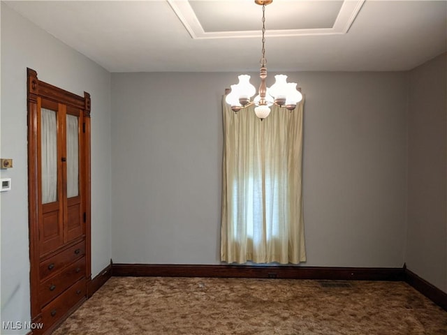 carpeted empty room with a notable chandelier