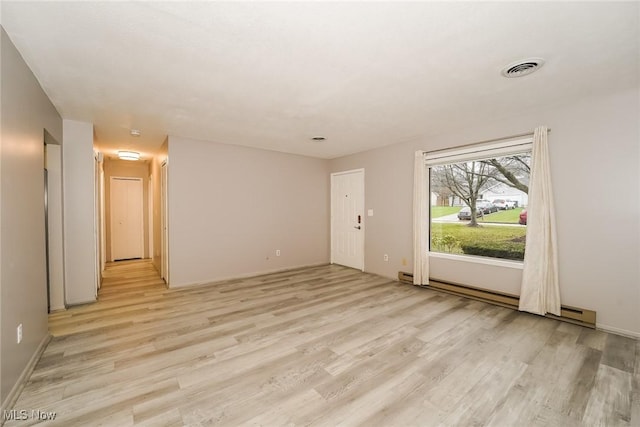 empty room with a baseboard radiator and light hardwood / wood-style flooring