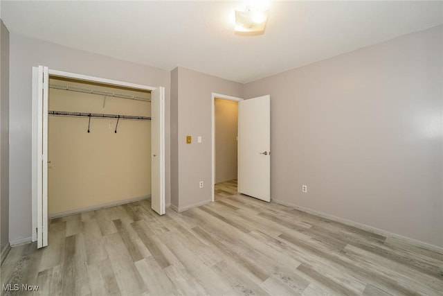 unfurnished bedroom featuring light wood-type flooring and a closet