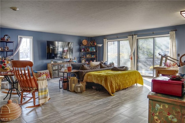 bedroom with a textured ceiling and multiple windows