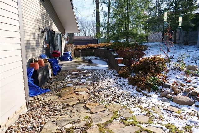 yard covered in snow with a patio area