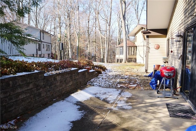 snowy yard featuring a patio area