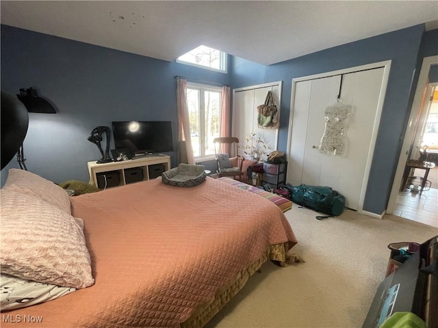 carpeted bedroom featuring multiple closets